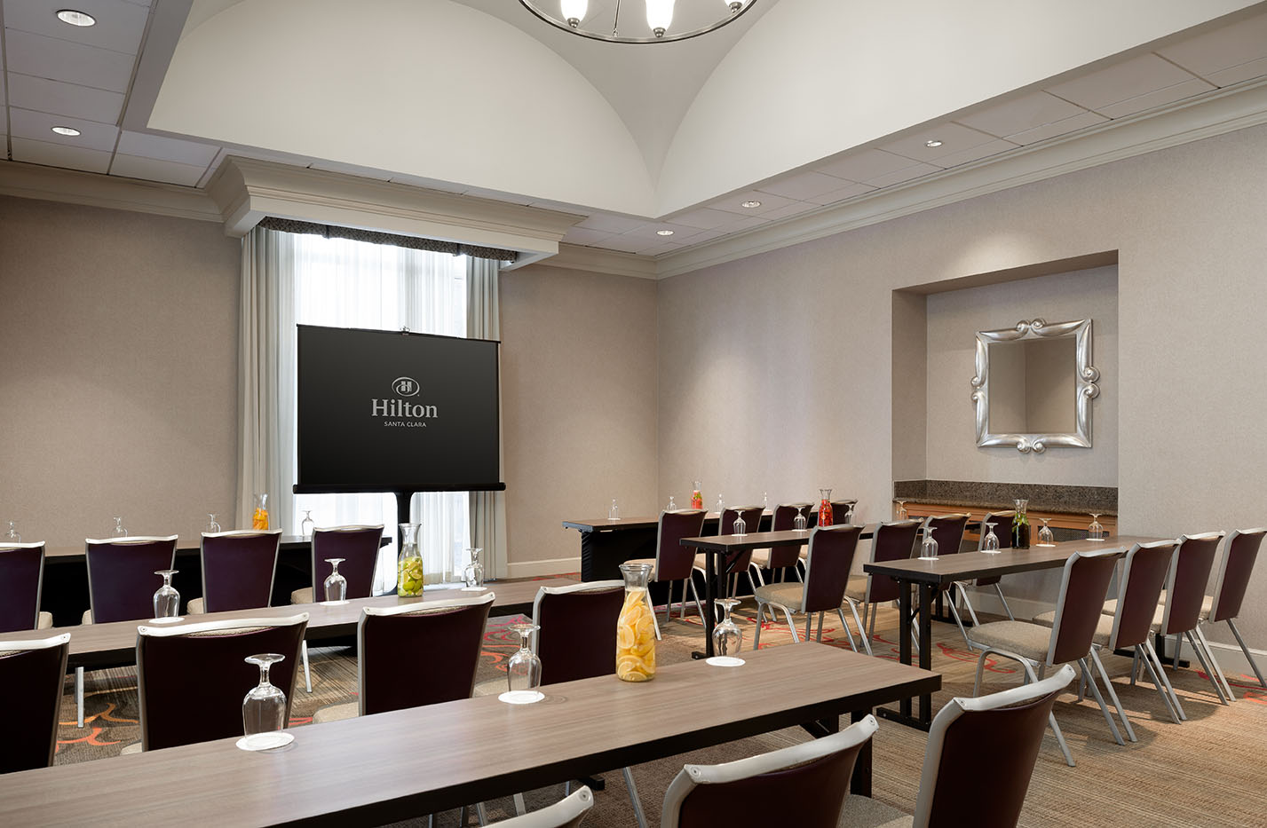 Conference-style meeting room setup at Hilton Santa Clara with drinks and notepads, part of Santa Clara catering for events offerings.